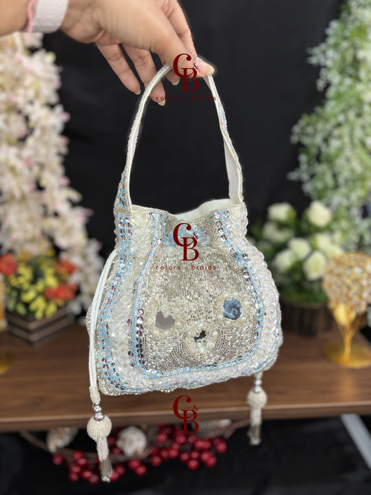 Handcrafted velvet potli bag featuring crystal, cutdana, mirror work, bead embellishments, and tassel drawstrings for weddings and festive occasions.