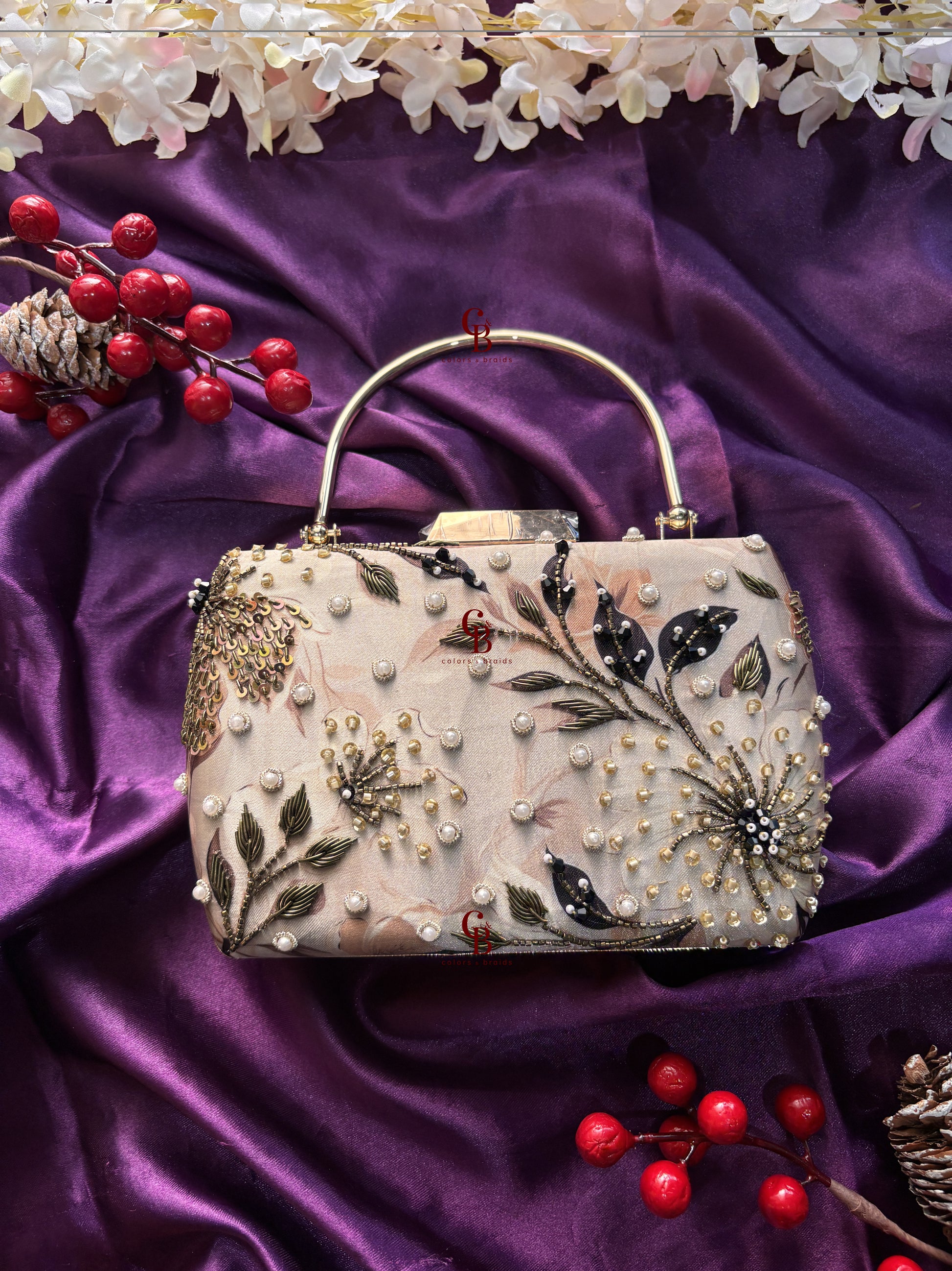 Decorative handbag with floral and pearl details on a purple fabric background