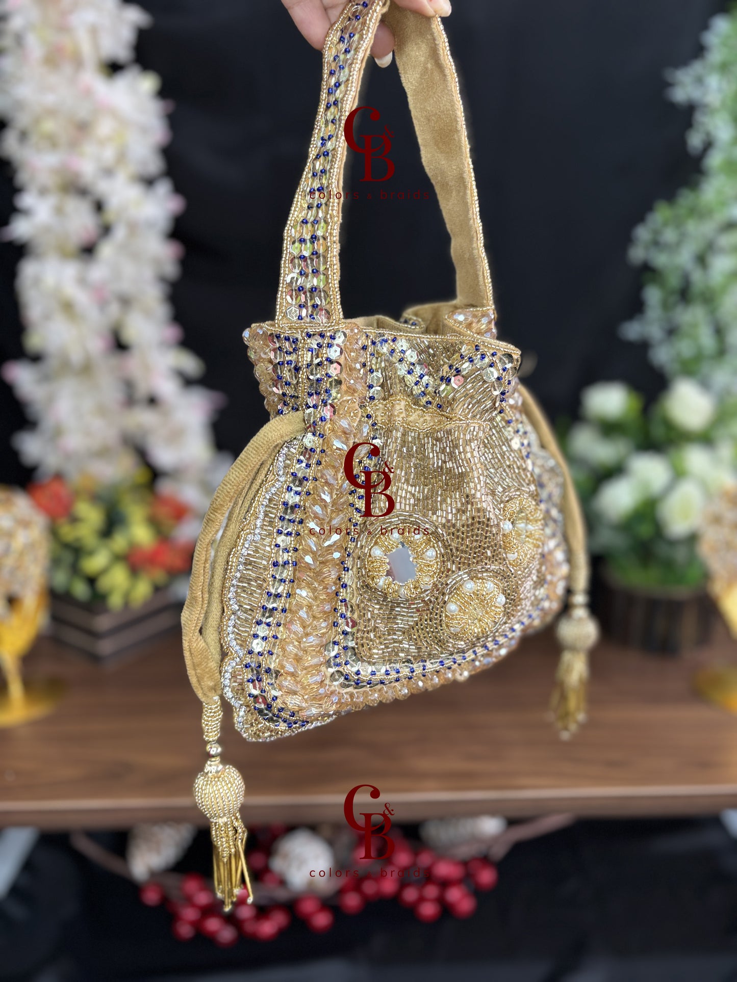 Handcrafted velvet potli bag featuring crystal, cutdana, mirror work, bead embellishments, and tassel drawstrings for weddings and festive occasions.