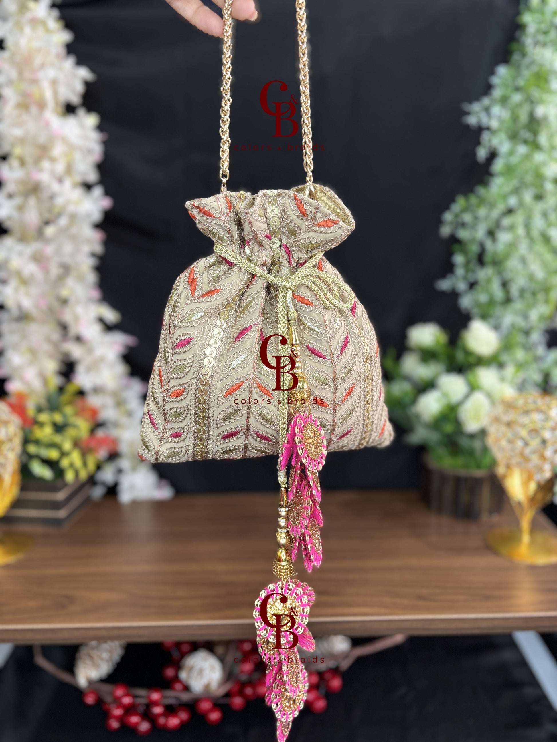Cream embroidered wedding potli with pink tassels and drawstring closure