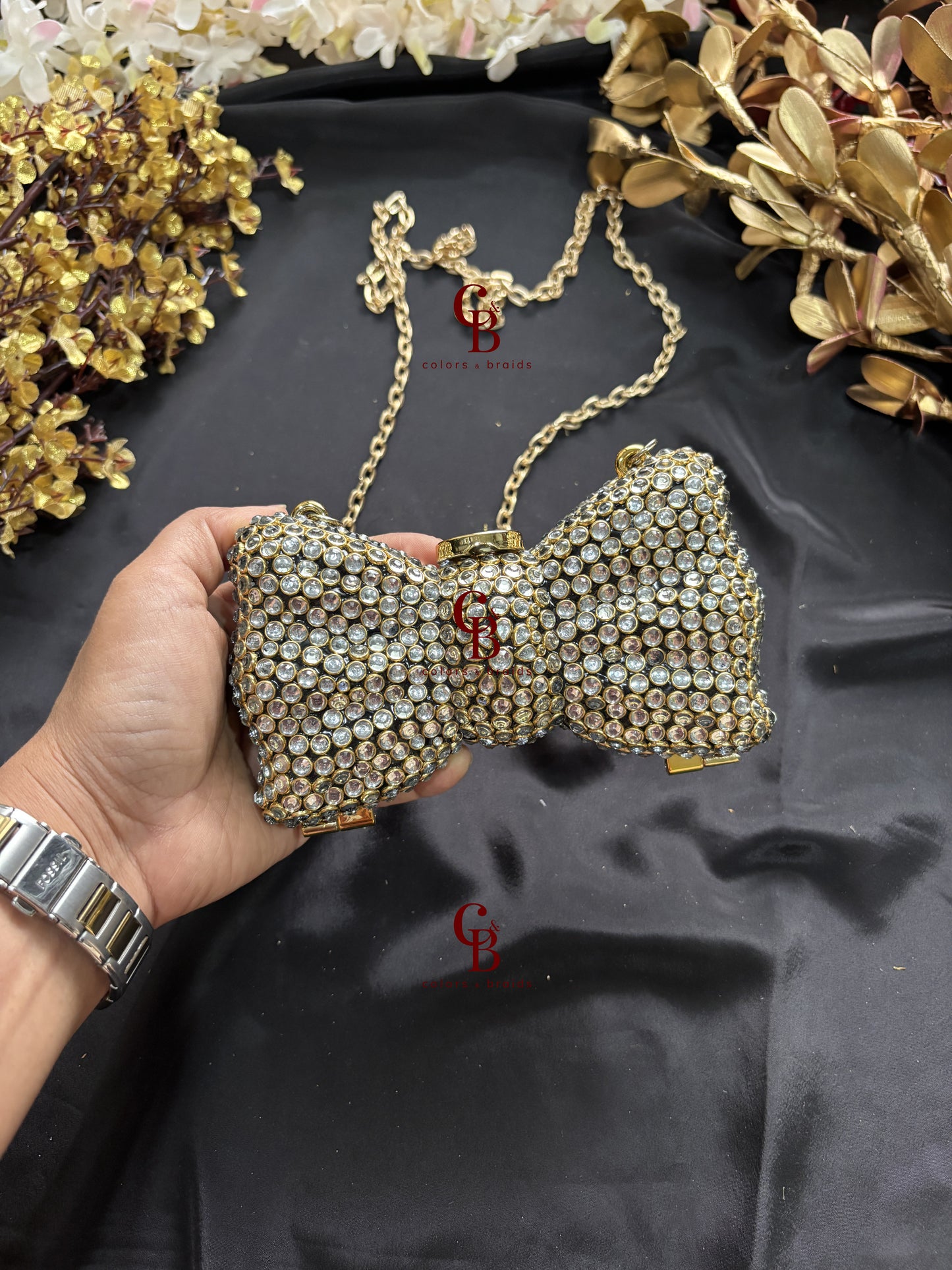 Gold Kundan bow-shaped clutch with crystal embellishment and chain strap